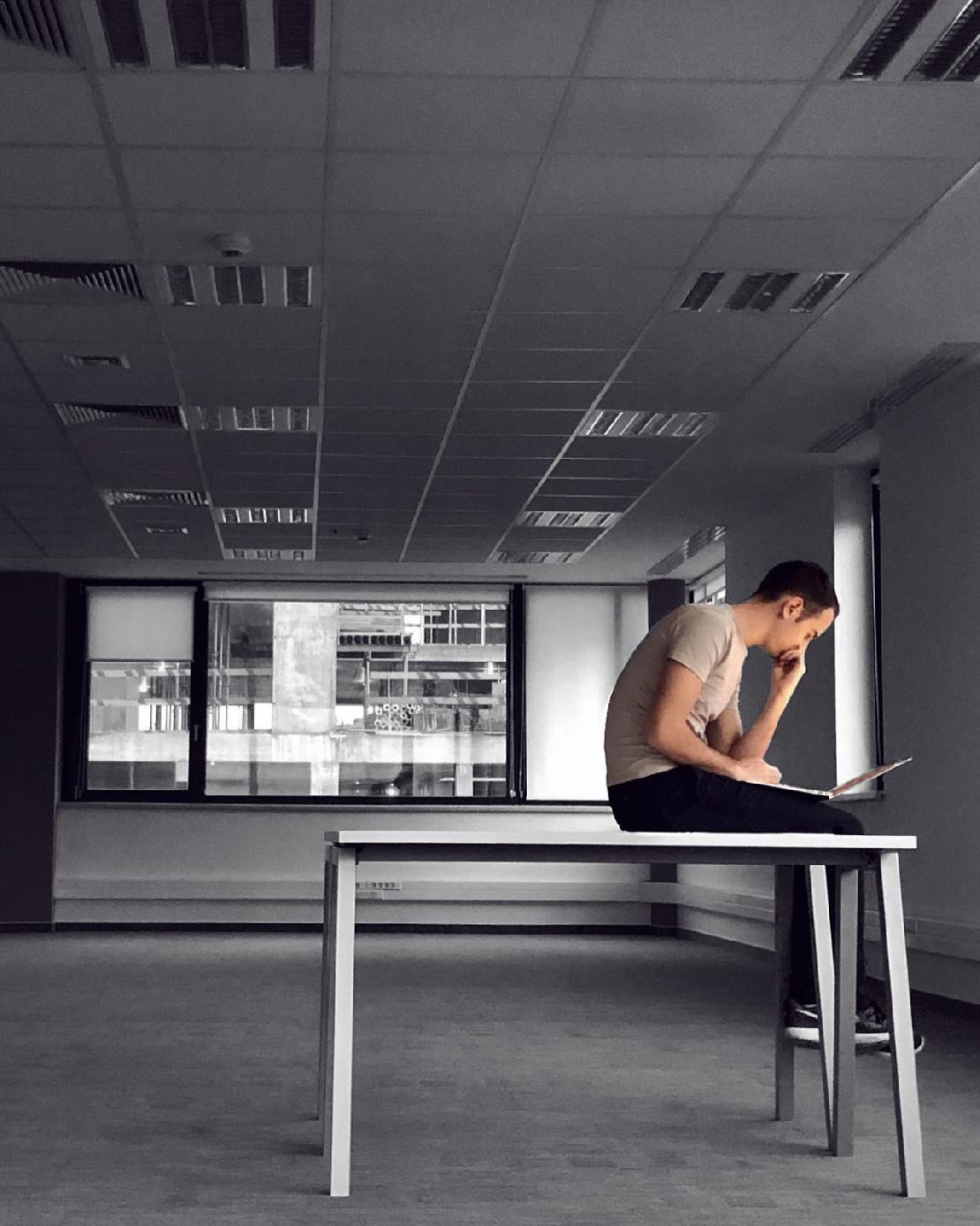 Galántai Gábornak ül egy fehér asztalon az új CoinCash irodában és dolgozik a laptopján. 